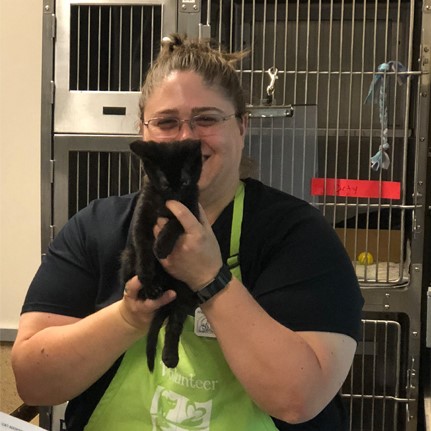 woman holding a kitten and smiling