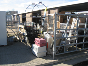 Cat carriers, ladders and other objects in a pile in the barn area